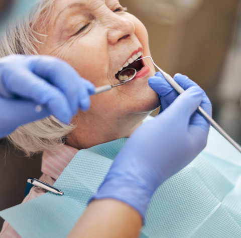 happy-senior-woman-getting-dental-checkup-962x950