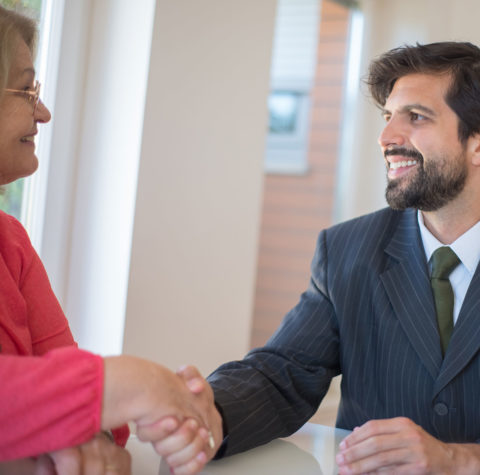 professional-man-shaking-hands-with-senior-woman-1600x1439